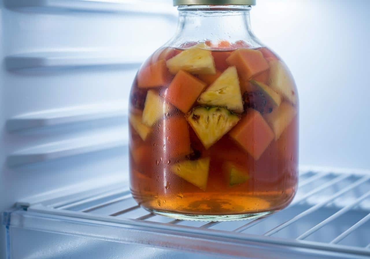Bouteille de punch aux fruits en macération au réfrigérateur