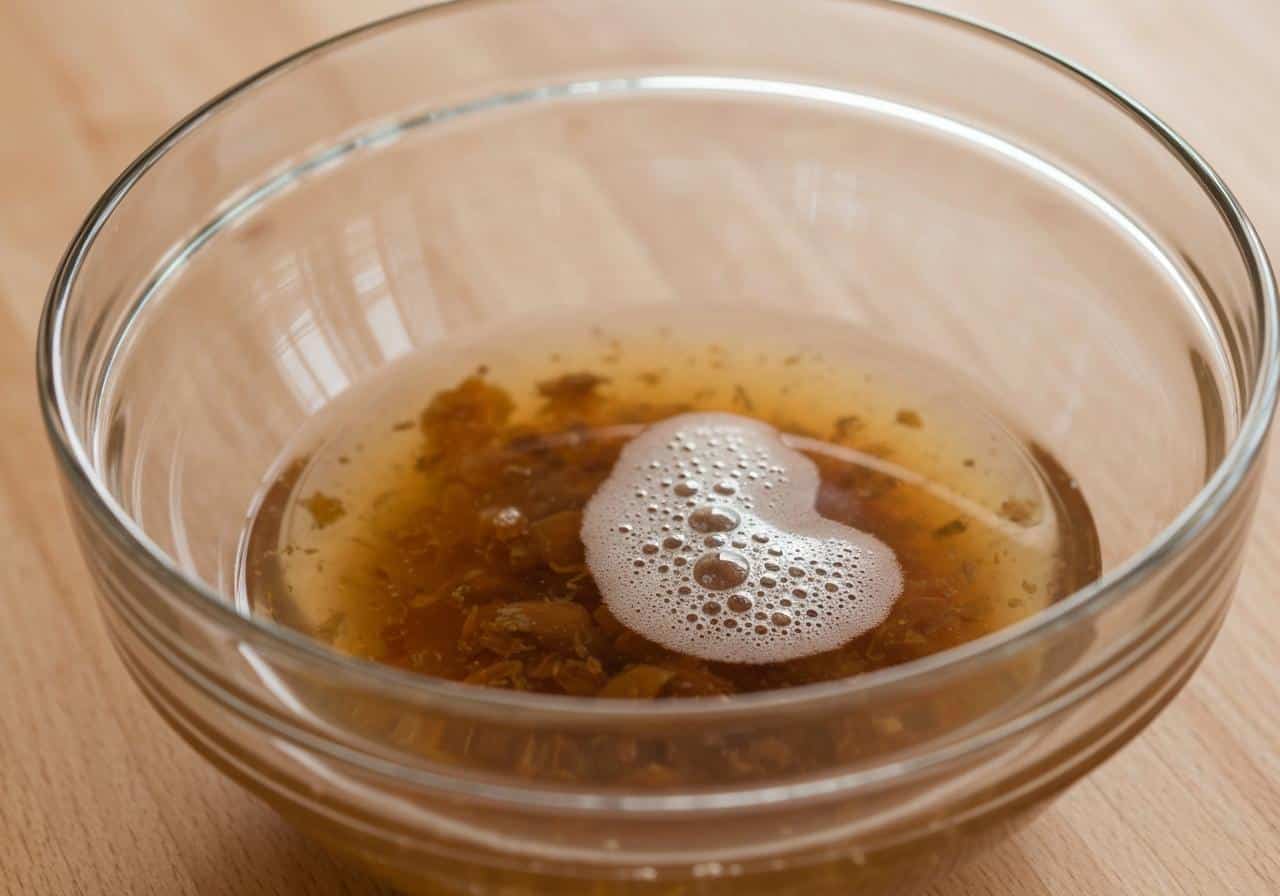 Pot de conserve de pois chiches ouvert, liquide épais versé dans un bol en verre, fond cuisine naturelle