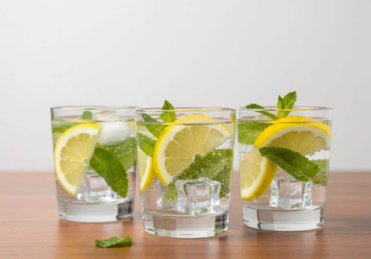 Verres d'eau pétillante citron menthe sur table bois